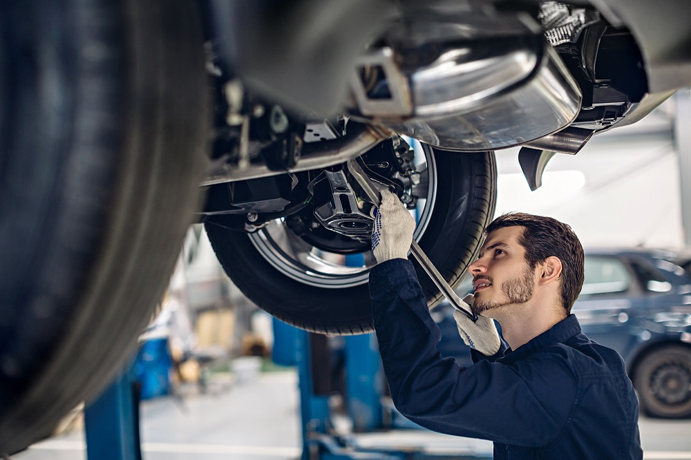 Mechanic working under a lifted car.